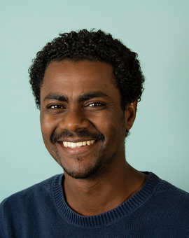 A photo of Adem Abebe smiling.