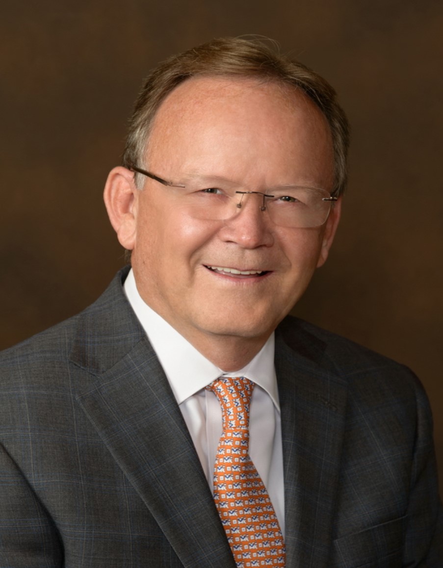 President J. Stuart Adams, in a charcoal suit, white dress shirt and orange patterned tie