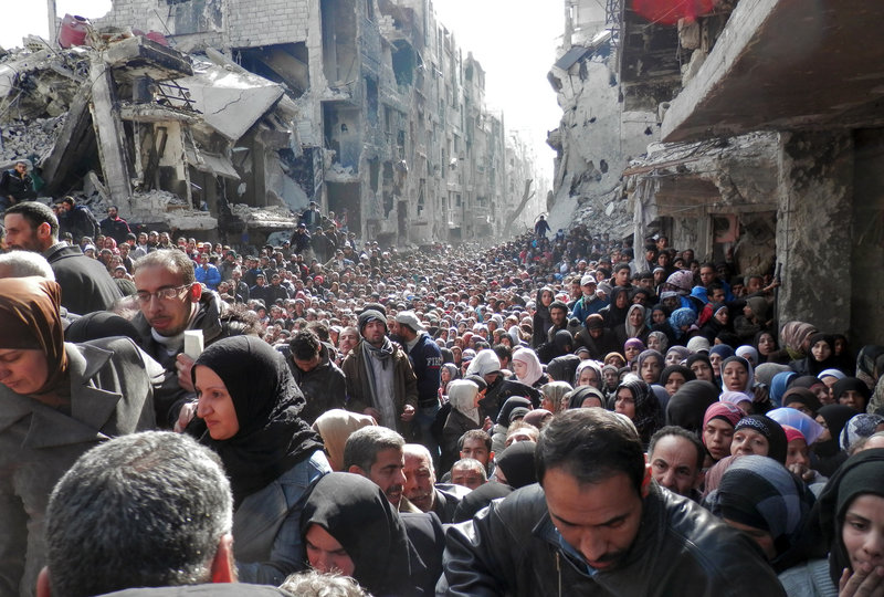   Masses of refugees wait in line to receive food aid distributed in the Yarmouk camp on Jan. 31 in Damascus, Syria. United Nation Relief and Works Agency/Getty Images 