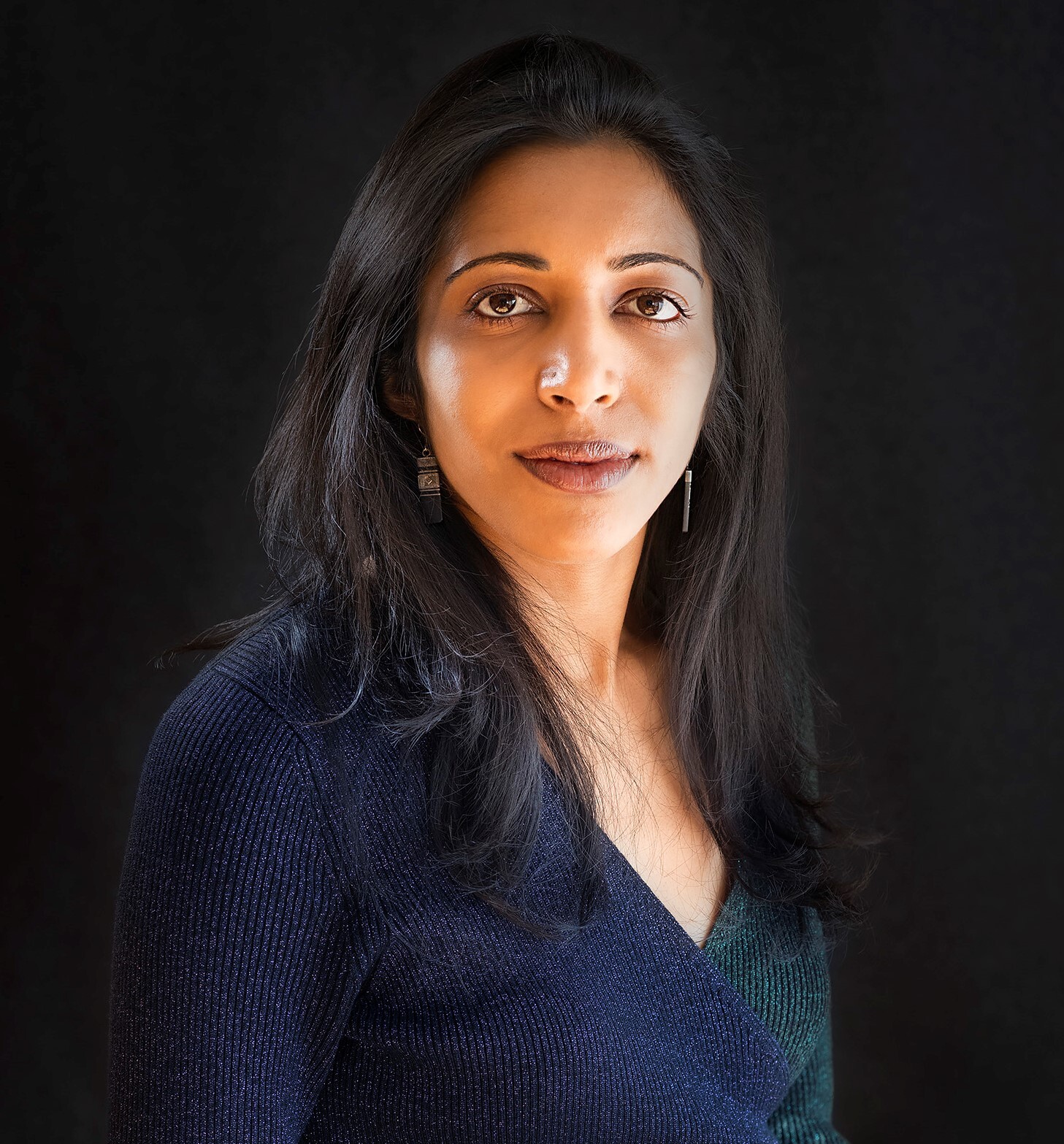 A picture of Vidhya Ramalingam in a dark blue and green jumper.
