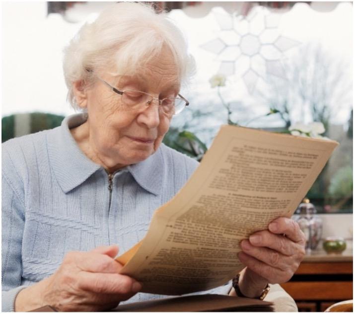 Older lady reading a printed document.